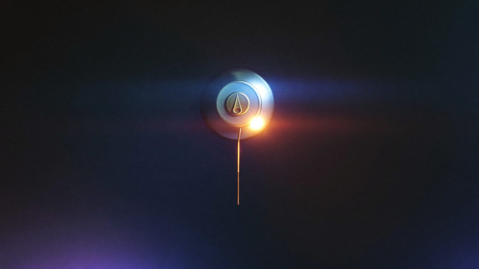 Un timbre de bronce en una pared oscura con su cable cortado colgando, los extremos de cobre brillando apenas.